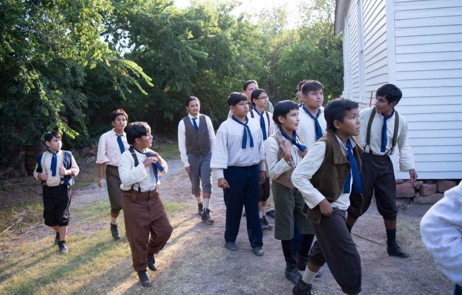 Actors from "Ghosts" walk around the schoolhouse during filming in Oklahoma.